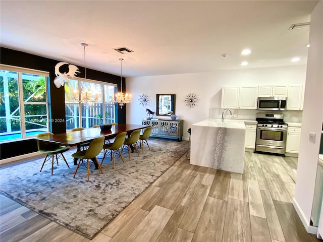 dining room with an inviting chandelier and light wood-type flooring