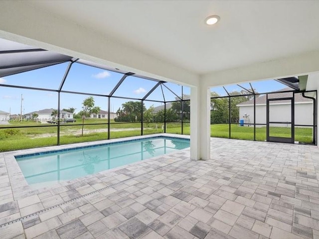 view of swimming pool featuring a lawn, a lanai, and a patio area