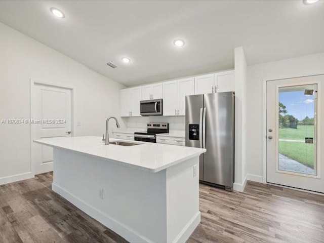 kitchen with an island with sink, appliances with stainless steel finishes, sink, and white cabinetry