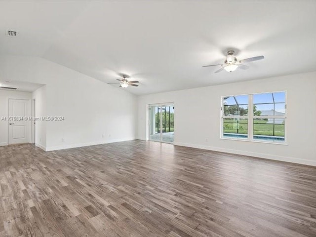 empty room with vaulted ceiling, ceiling fan, and hardwood / wood-style flooring