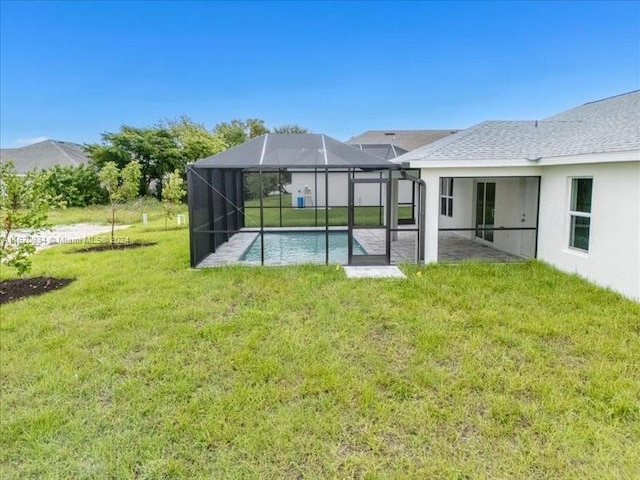 back of house featuring a patio, glass enclosure, and a yard