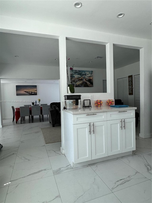 kitchen with white cabinets and light stone countertops