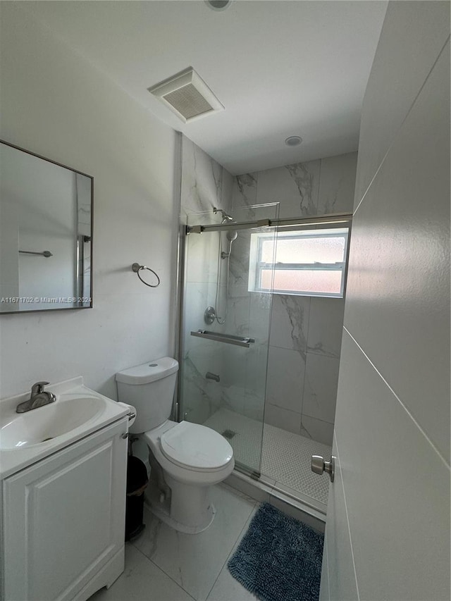 bathroom with a shower with door, vanity, and toilet