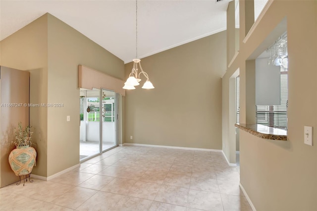 empty room with light tile patterned floors, a chandelier, and high vaulted ceiling