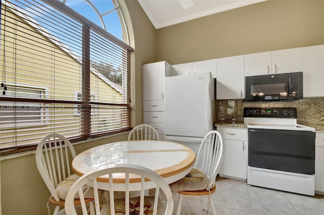 kitchen with a healthy amount of sunlight, white appliances, white cabinetry, and tasteful backsplash