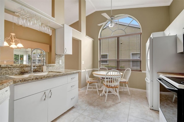 kitchen with ceiling fan with notable chandelier, sink, a healthy amount of sunlight, and white cabinetry