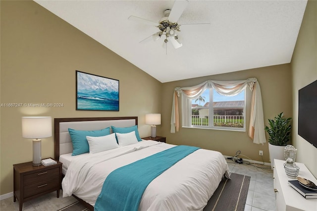 bedroom featuring ceiling fan, light tile patterned floors, and vaulted ceiling