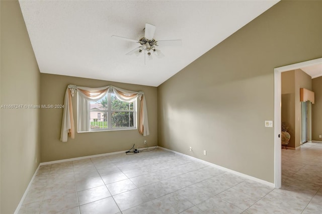 spare room featuring ceiling fan, light tile patterned flooring, and lofted ceiling