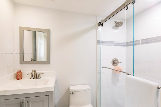 bathroom featuring vanity, toilet, and walk in shower