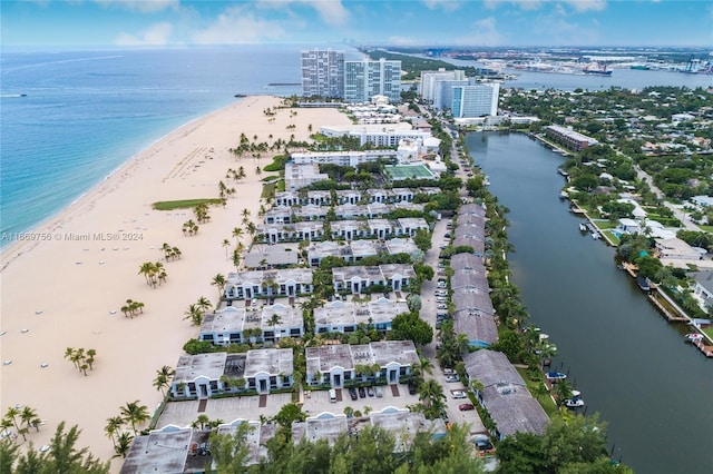 birds eye view of property with a water view and a beach view