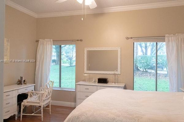 bedroom with ceiling fan, dark hardwood / wood-style floors, and multiple windows