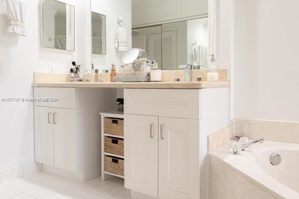 bathroom featuring vanity, tile patterned floors, and a relaxing tiled tub