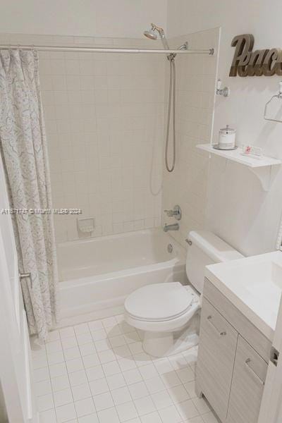 full bathroom featuring shower / tub combo, vanity, toilet, and tile patterned floors