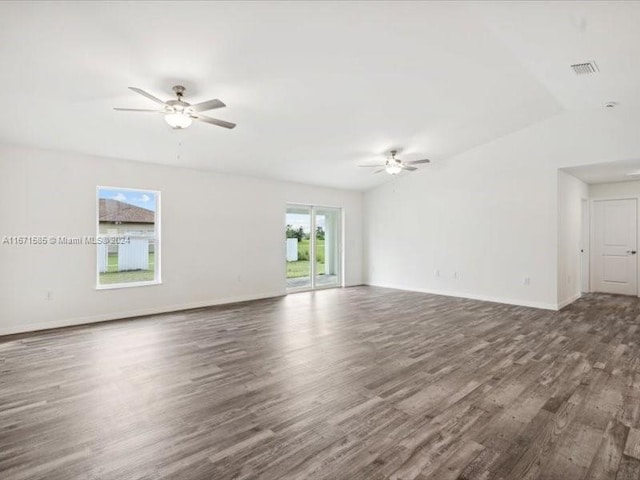 empty room with dark wood-type flooring, ceiling fan, and lofted ceiling