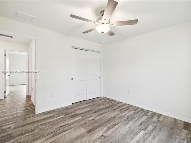 unfurnished bedroom with a closet, ceiling fan, and hardwood / wood-style flooring