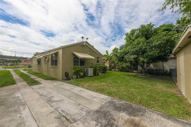 view of side of home featuring a yard and central air condition unit