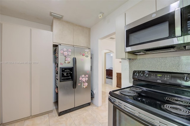 kitchen with decorative backsplash, stainless steel appliances, and light tile patterned floors