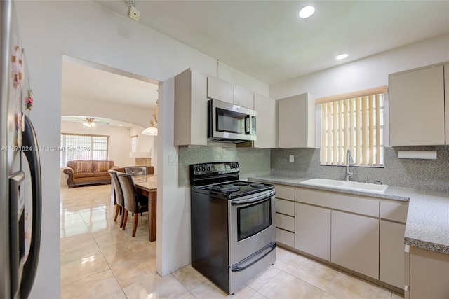 kitchen featuring ceiling fan, stainless steel appliances, backsplash, and sink