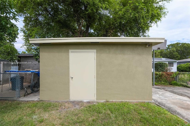 view of outbuilding featuring a trampoline and a yard