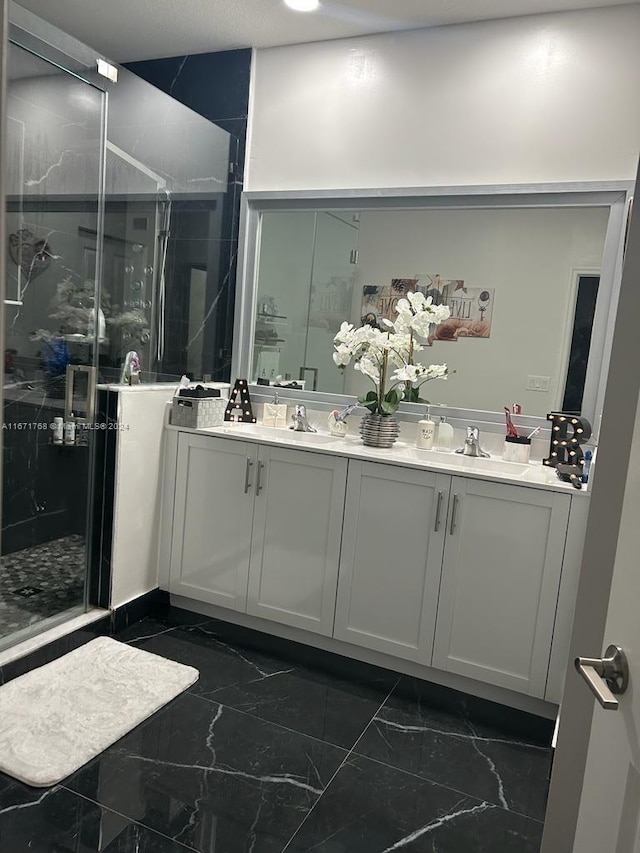 bathroom featuring a shower with shower door and vanity