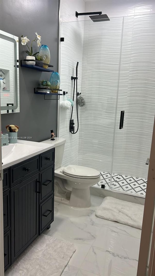 bathroom featuring vanity, toilet, and a shower with door