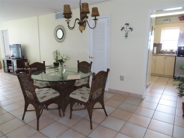 tiled dining area featuring an inviting chandelier