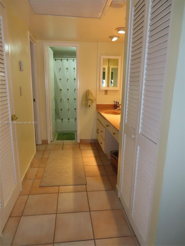 bathroom featuring tile patterned flooring, walk in shower, and vanity