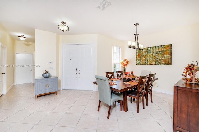 tiled dining room with a notable chandelier