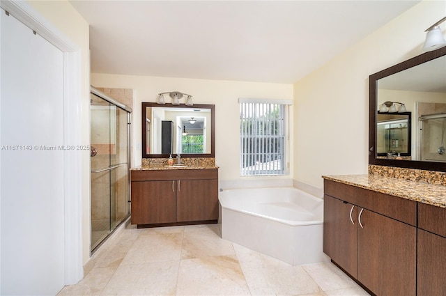 bathroom with a shower stall, a garden tub, two vanities, and tile patterned floors