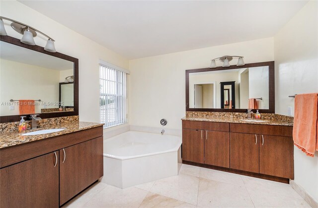 bathroom featuring tile patterned floors, vanity, and a bath