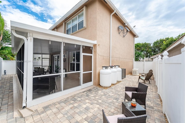 view of patio featuring a sunroom, a fenced backyard, and cooling unit