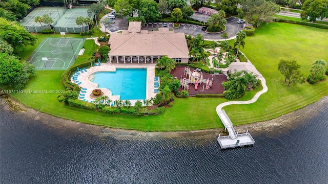 drone / aerial view of a pool and a nearby body of water
