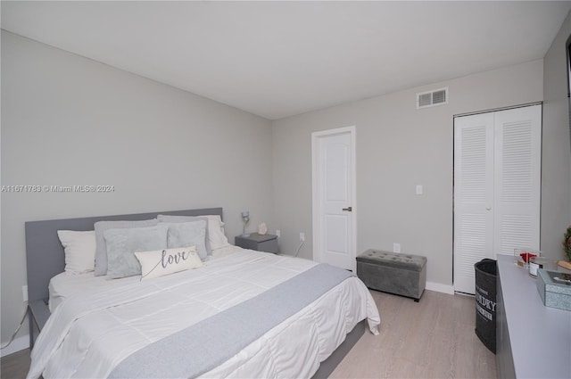 bedroom with light hardwood / wood-style flooring and a closet