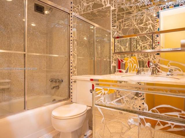 full bathroom with vanity, combined bath / shower with glass door, tile patterned flooring, and toilet