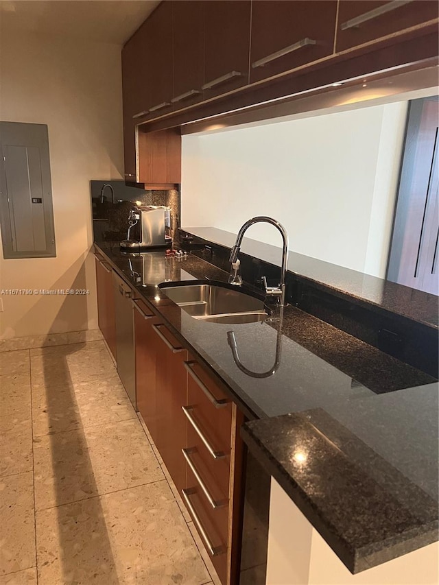 kitchen with dark stone countertops, electric panel, sink, and kitchen peninsula