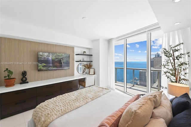 bedroom featuring light tile patterned floors, recessed lighting, a water view, access to outside, and expansive windows