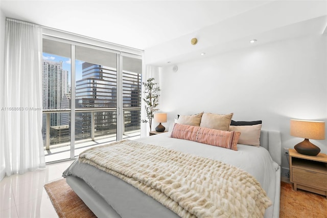 tiled bedroom with access to exterior, a wall of windows, and a city view