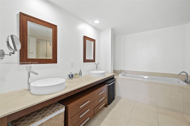 full bathroom featuring a garden tub, double vanity, a sink, and recessed lighting