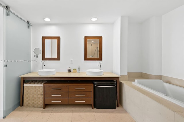 full bathroom featuring double vanity, a garden tub, a sink, and tile patterned floors