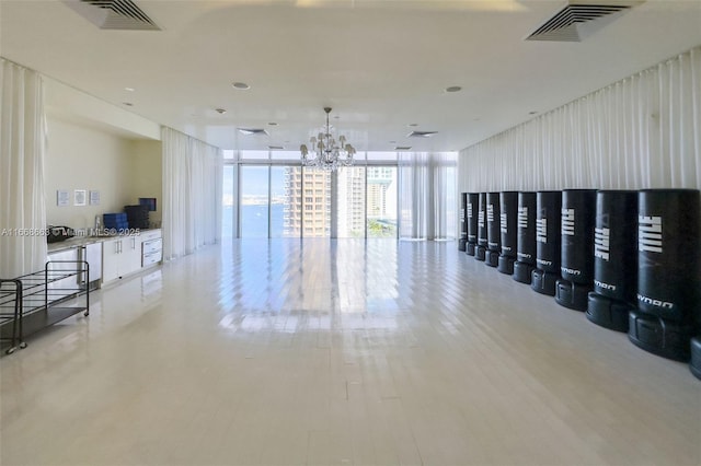 spare room featuring expansive windows, visible vents, and a notable chandelier