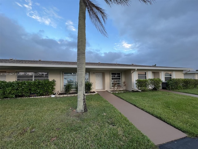 ranch-style home featuring a front lawn