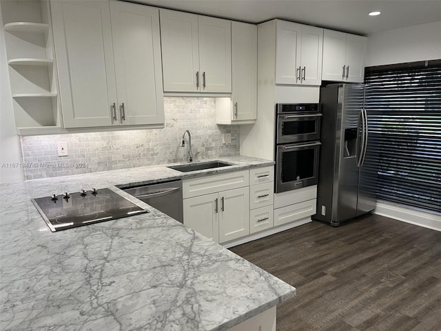 kitchen featuring appliances with stainless steel finishes, sink, dark wood-type flooring, and white cabinets