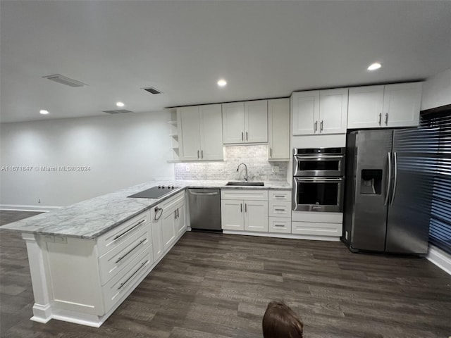 kitchen featuring stainless steel appliances, white cabinetry, kitchen peninsula, and sink