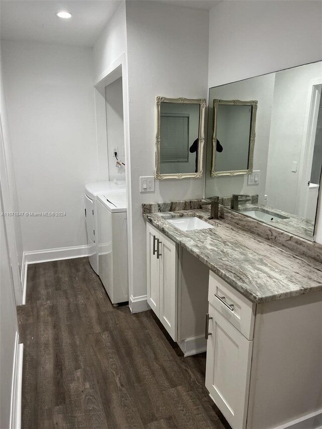 bathroom featuring vanity, washing machine and clothes dryer, and hardwood / wood-style flooring