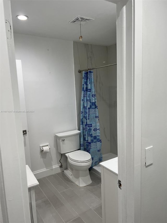 bathroom with vanity, toilet, and curtained shower