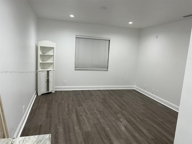 spare room with dark wood-type flooring