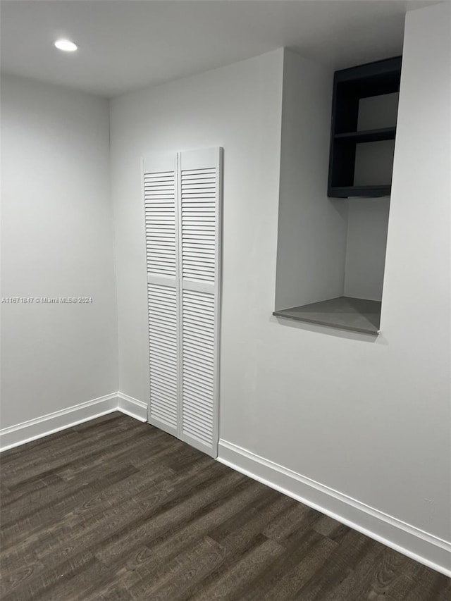 unfurnished bedroom with a closet and dark hardwood / wood-style floors