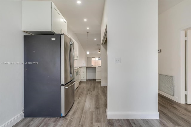 kitchen featuring white cabinetry, electric stove, stainless steel refrigerator, and light hardwood / wood-style flooring