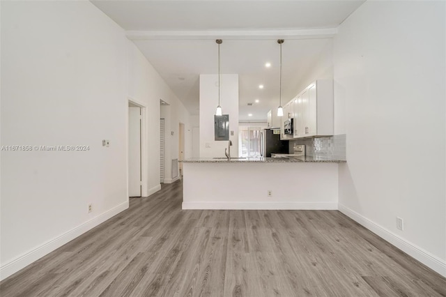 kitchen featuring light wood-type flooring, kitchen peninsula, pendant lighting, white cabinets, and light stone counters