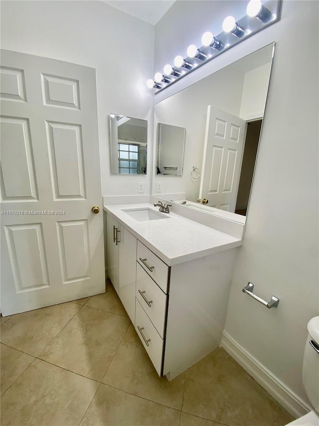 bathroom with tile patterned flooring, vanity, and toilet